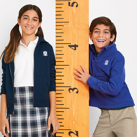 Two students holding an oversized ruler.