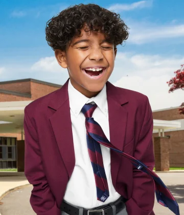 A boy wearing a school uniform with a blazer.