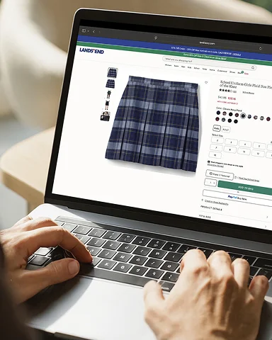 A person using a laptop to browse Lands' End school uniforms online
