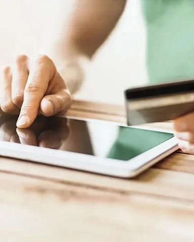 A person using an electronic tablet device to pay for a transaction