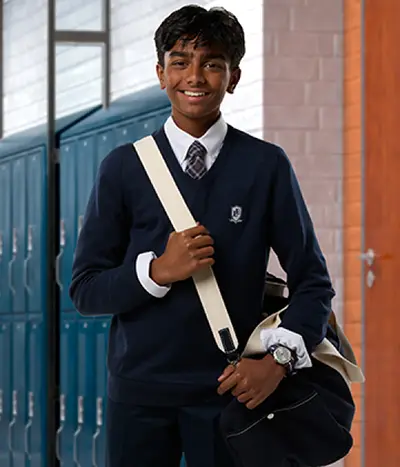 A student wearing a navy sweater with a black duffle bag.