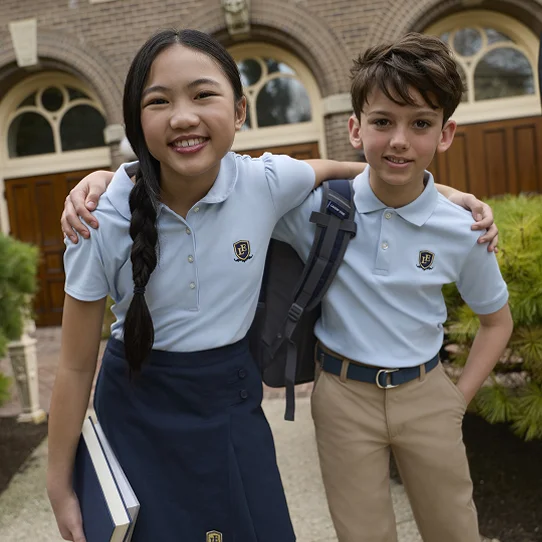Two students wearing blue school uniform polos